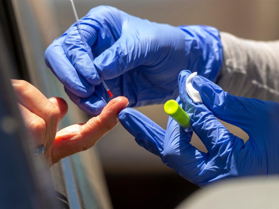 FILE - In this Wednesday, May 20, 2020 file photo, a health worker takes a blood sample for a COVID-19 antibody test in Los Angeles. An antibody test might show if you had COVID-19 in the recent past, which most experts think gives people some protection from the virus. (AP Photo/Damian Dovarganes)