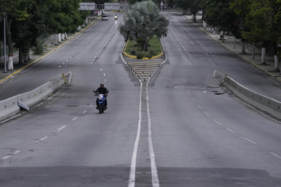 Un hombre conduce su motocicleta por una avenida vacía en Caracas, Venezuela, el lunes 29 de julio de 2024, el día después de las elecciones presidenciales. (AP Foto/Matías Delacroix)