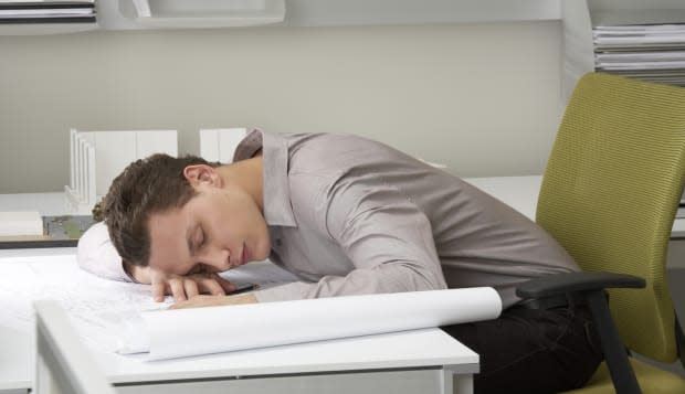 Young businessman asleep on desk