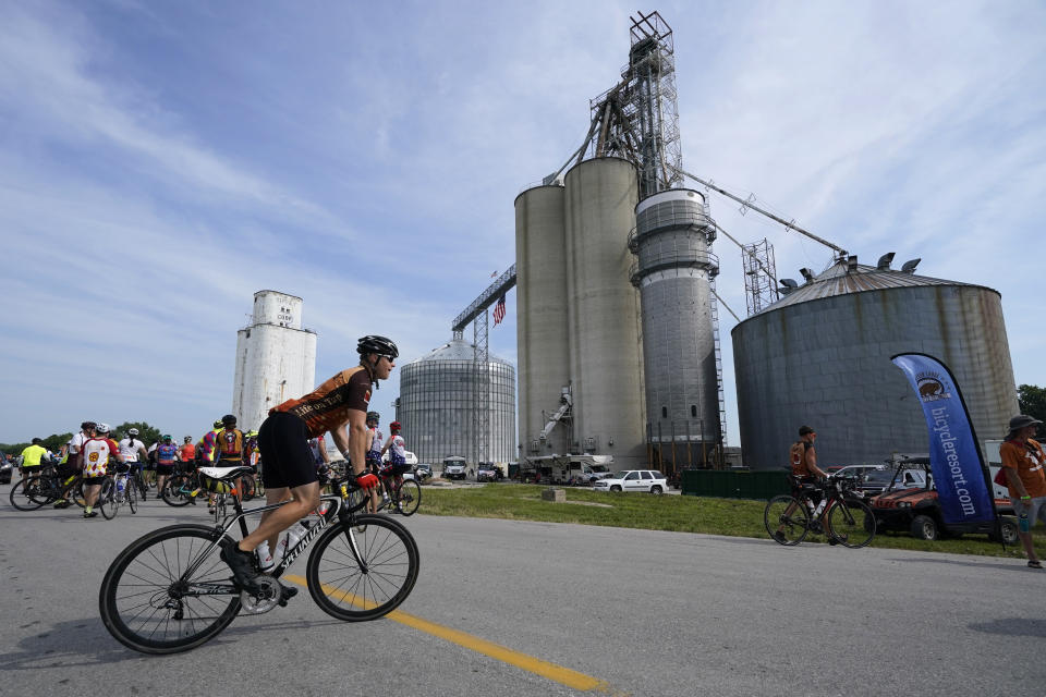 Associated Press reporter Dave Skretta rides past a grain elevator while riding in The Des Moines Register's annual bike ride across Iowa, also known as RAGBRAI, Tuesday, July 25, 2023, in Rippey, Iowa. (AP Photo/Charlie Neibergall)