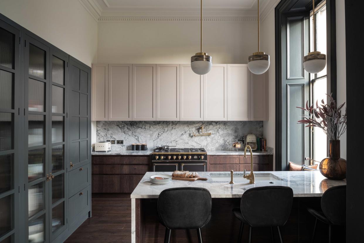  A grey kitchen with off-white walls. 