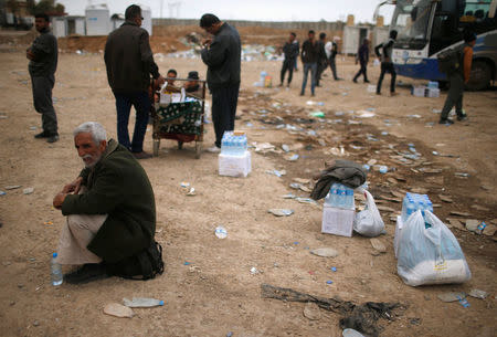 Displaced Iraqis wait to get food supplies as Iraqi forces battle with Islamic State militants, in western Mosul, Iraq March 28, 2017. REUTERS/Suhaib Salem