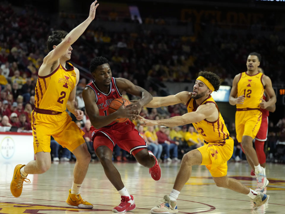 St. John's guard Montez Mathis (10) drives inside as Iowa State guards Caleb Grill (2) and Gabe Kalscheur (22) defend during the first half of an NCAA college basketball game, Sunday, Dec. 4, 2022, in Ames, Iowa. (AP Photo/ Matthew Putney)