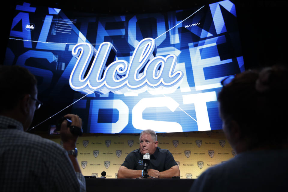 FILE - In this July 25, 2018, file photo, UCLA coach Chip Kelly talks to reporters at the Pac-12 Conference NCAA college football media day in Los Angeles. When specifics about Title IX reporting requirements were added to Arizona basketball coach Sean Miller’s contract this year, the school said to expect similar language in its other coaching contracts. UCLA is taking the same approach, including for football coach Kelly. (AP Photo/Jae C. Hong, File)