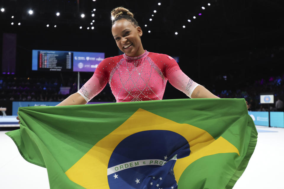 Brazil's Rebeca Andrade celebrates with the national flag after winning the gold medal on the vault during the apparatus finals at the Artistic Gymnastics World Championships in Antwerp, Belgium, Saturday, Oct. 7, 2023. (AP Photo/Geert vanden Wijngaert)