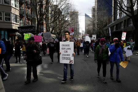 Demonstrators carry signs during a "March for Our Lives" demonstration demanding gun control in Seattle, Washington, U.S. March 24, 2018. REUTERS/Jason Redmond