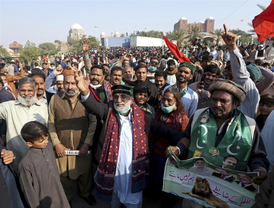 Supporters of the Pakistan Democratic Movement, an alliance of opposition parties, gather at a main intersection before an anti-government rally in Multan, Pakistan, Monday, Nov. 30, 2020. Pakistani police arrested hundreds of supporters of opposition parties ahead of a planned rally Monday calling for the country's prime minister to resign, a move the government defended as necessary to combat the coronavirus pandemic. (AP Photo/Asim Tanveer)
