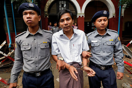 Detained Reuters journalist Kyaw Soe Oo is escorted by police officers as he leaves Insein court in Yangon, Myanmar July 30, 2018. REUTERS/STRINGER