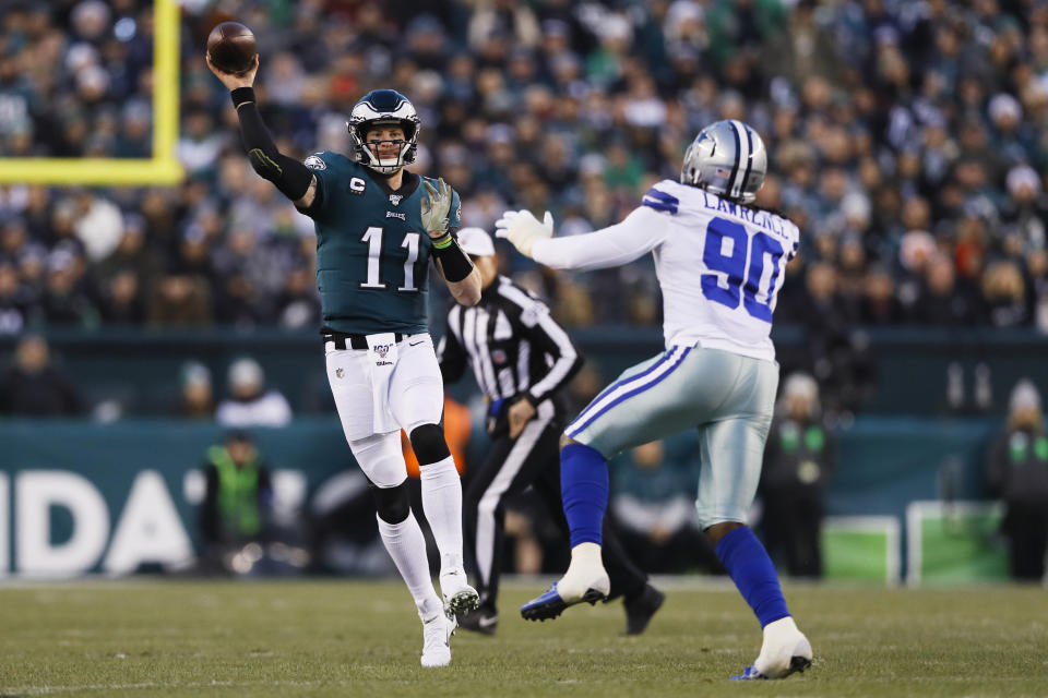 Philadelphia Eagles quarterback Carson Wentz (11) throws a pass as Dallas Cowboys defensive end Demarcus Lawrence defends during the first half of an NFL football game Sunday, Dec. 22, 2019, in Philadelphia. (AP Photo/Michael Perez)