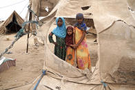 <p>ABS IDP Settlement, Yemen, May 6, 2017: Displaced children stand in the shredded remains of tents in Abs settlement for internally displaced persons (IDPs). Located just 40 km from the frontlines, the settlement is regularly damaged by passing sandstorms. (Photograph by Giles Clarke for UN OCHA/Getty Images) </p>