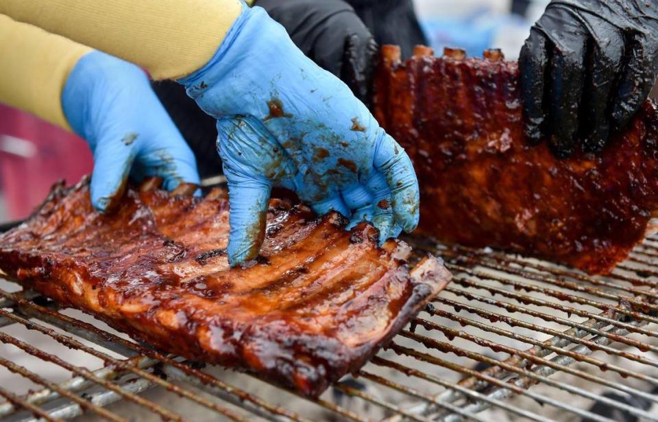 Volunteers with Operation BBQ Relief flip over some ribs they are carmelizing. The three-day Kansas City BBQ Festival in the parking lot of the GEHA Field at Arrowhead Stadium concluded Sunday, July 11, 2021.