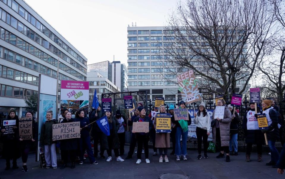 Striking nurses are pictured on a picket line outside St. Thomas' Hospital in central London today - Carlos Jasso/Bloomberg