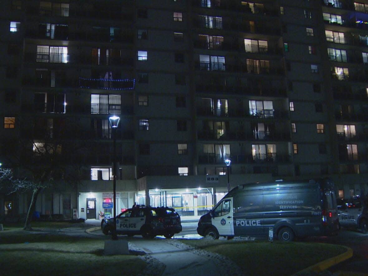 Toronto police vehicles are parked outside a Scarborough high-rise building after a shooting seriously injured a man on Wednesday. (CBC - image credit)