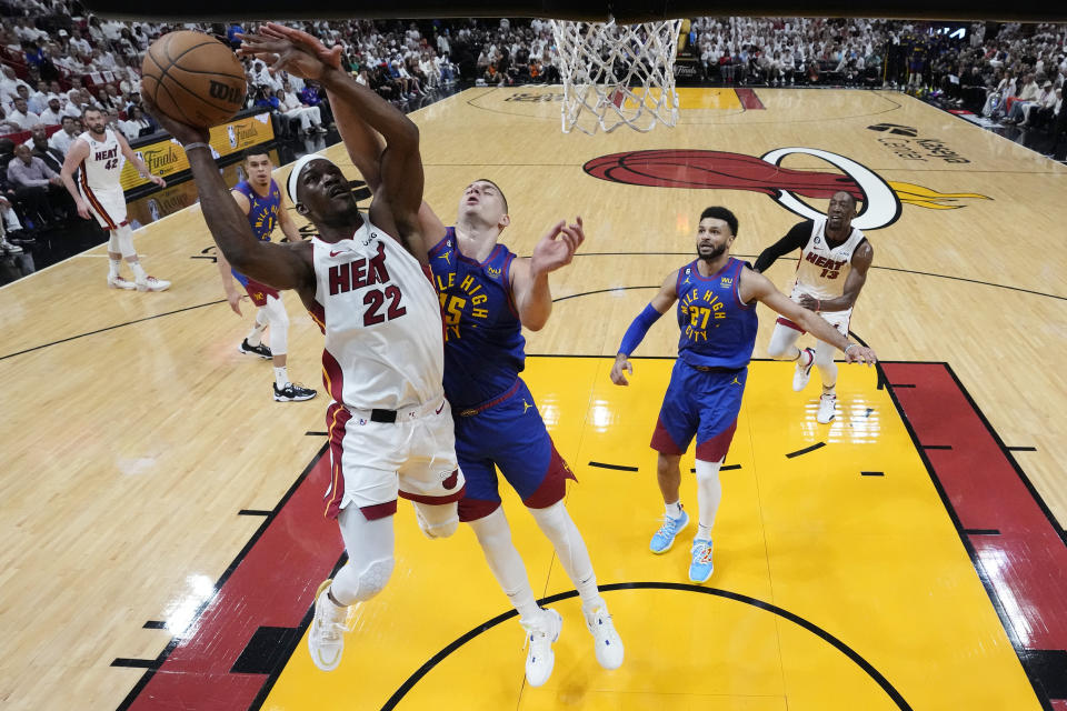 Miami Heat forward Jimmy Butler (22) drives to the basket as Denver Nuggets center Nikola Jokic (15) defends during the first half of Game 3 of the NBA Finals basketball game, Wednesday, June 7, 2023, in Miami. (AP Photo/Wilfredo Lee)