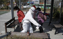 Members of a local residents group wear protective gear as they disinfect a local park as a precaution against the new coronavirus in Seoul, South Korea, Monday, March 23, 2020. For most people, the new coronavirus causes only mild or moderate symptoms. For some it can cause more severe illness. (AP Photo/Lee Jin-man)