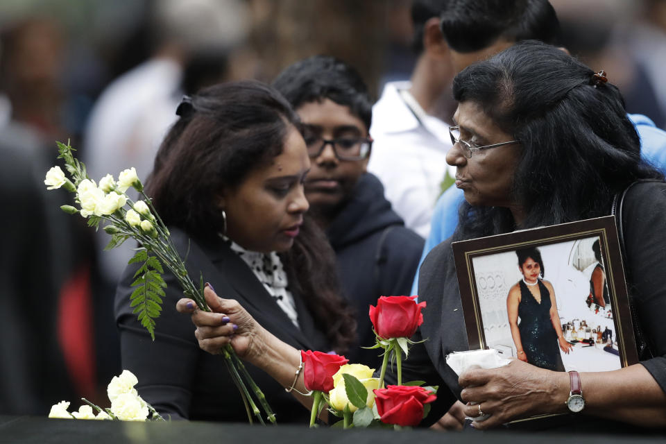 <p>A woman leaves flowers at the North Pool during a ceremony marking the 17th anniversary of the terrorist attacks on the United States on Tuesday, Sept. 11, 2018, in New York. (Photo: Mark Lennihan/AP) </p>