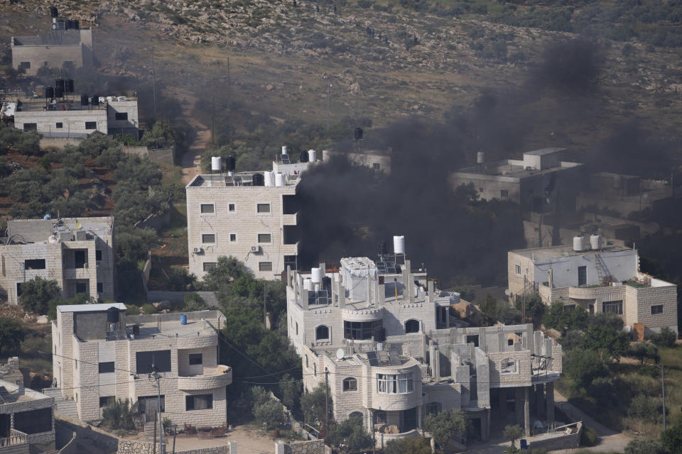 Smoke fills the sky after Israeli settlers set fire to the properties of Palestinian villagers in the West Bank village of al-Mughayyir, Saturday, April 13, 2024. Israel's army says the body of a missing Israeli teen has been found in the occupied West Bank after he was killed in a "terrorist attack." The disappearance of 14-year-old Binyamin Achimair sparked a large attack by settlers on the Palestinian village on Friday and Saturday. (AP Photo/Nasser Nasser)