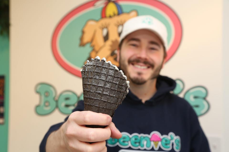 Morristown, NJ - April 3, 2024 -- Beenie's Ice Cream in Morristown is offering a black cocoa waffle cone with stardust (edible glitter) to commemorate the upcoming solar eclipse. They will also give a pair of eclipse glasses with the first 50 purchases of the eclipse cone. Tony Franco, owner of Beenie's Ice Cream with the black cocoa waffle cone with stardust (edible glitter).