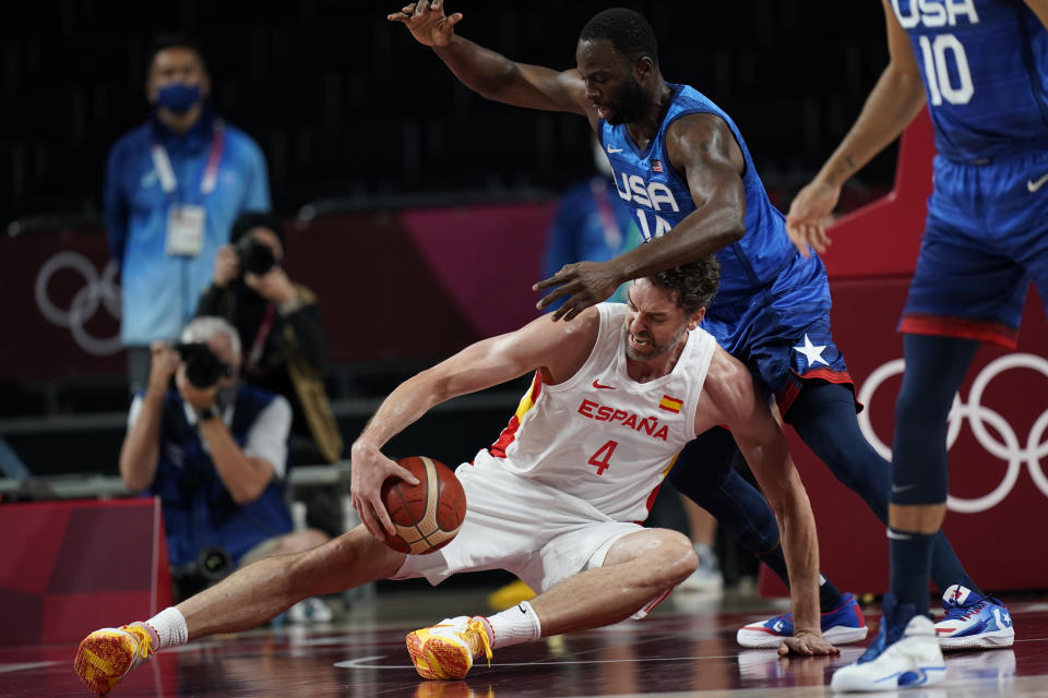 Spain's Pau Gasol (4), on court, and United States' Draymond Green (14) scramble for a ball during men's basketball quarterfinal game at the 2020 Summer Olympics, Tuesday, Aug. 3, 2021, in Saitama, Japan. (AP Photo/Eric Gay)