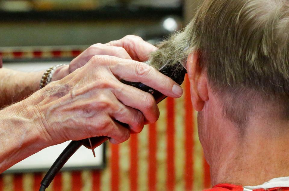 The steady hands of John Antonie trim the hair on Rick Blahnik, of Two Rivers, Tuesday, August 22, 2023, in Two Rivers, Wis.