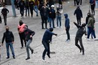 Masked demonstrators throw stones as they protest outside the venue of a campaign rally for Marine Le Pen, French National Front (FN) political party leader and candidate for French 2017 presidential election in Paris, France, April 17, 2017. REUTERS/Philippe Wojazer