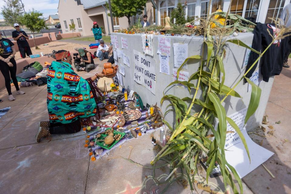 Activists place offerings at an empty pedestal where Rio Arriba County officials had planned to install a statue of Spanish conquistador (AP)