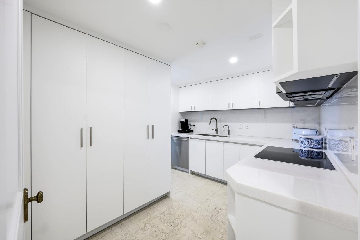 White cabinetry and stainless-steel appliances give the kitchen a sleek feel.