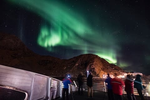 Passengers observing the Northern Lights in Norway on board the Hurtigruten - Credit: Getty