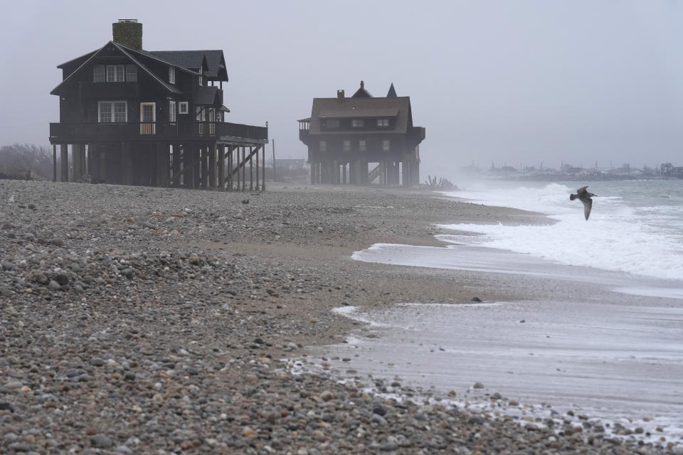 Houses resting on pylons are elevated above the beach, Thursday, Jan. 25, 2024, in South Kingstown, R.I. Experts say erosion and receding shorelines are becoming more common due to ocean rise and climate change. (AP Photo/Steven Senne)