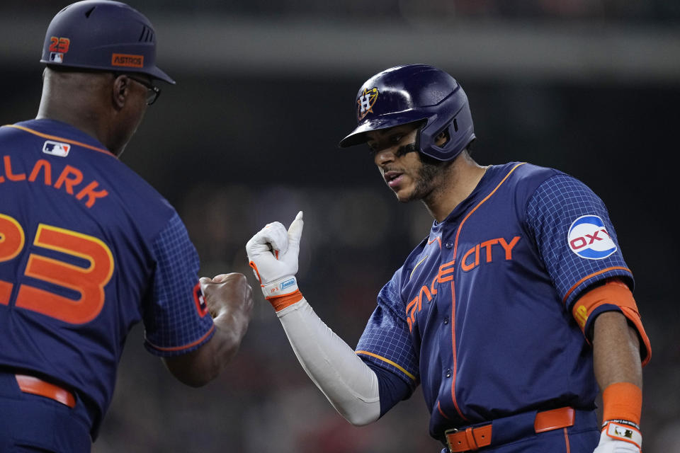 Houston Astros' Jeremy Pena, right, is congratulated by first base coach Dave Clark after hitting a two-run single during the sixth inning of a baseball game against the Toronto Blue Jays, Monday, April 1, 2024, in Houston. (AP Photo/Kevin M. Cox)