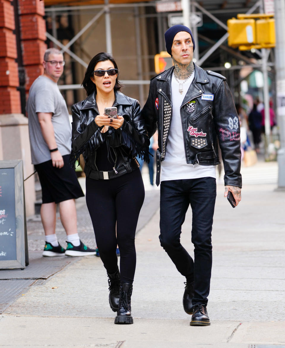 The couple walking down a street as a man stares at them