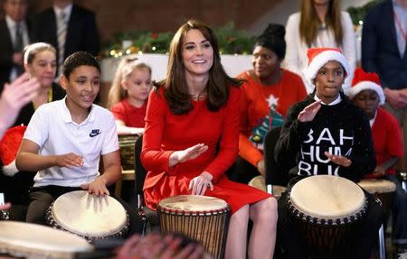 Britain's Catherine, Duchess of Cambridge takes part in some drumming 'music therapy' as she attends the Anna Freud Centre Family School Christmas Party at Anna Freud Centre, in London, December 15, 2015. REUTERS/Chris Jackson/Pool/Files