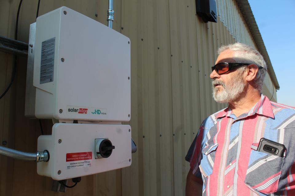 Olaf Stimac, a retired pipefitter who lives outside Great Falls, explains the workings of a solar converter installed at a shop outside his home.