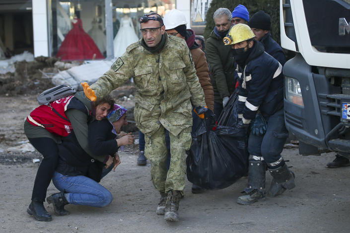 A woman reacts as rescue workers carry the body of an earthquake victim in Adiyaman, southeastern Turkey, Thursday, Feb. 9, 2023. Thousands who lost their homes in a catastrophic earthquake huddled around campfires and clamored for food and water in the bitter cold, three days after the temblor and series of aftershocks hit Turkey and Syria. (AP Photo/Emrah Gurel)