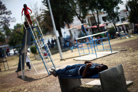 A Central American migrant, moving in a caravan through Mexico toward the U.S. border with fellow migrants, rests at a shelter set up for them in a park by the Catholic church, in Puebla, Mexico April 6, 2018. REUTERS/Edgard Garrido