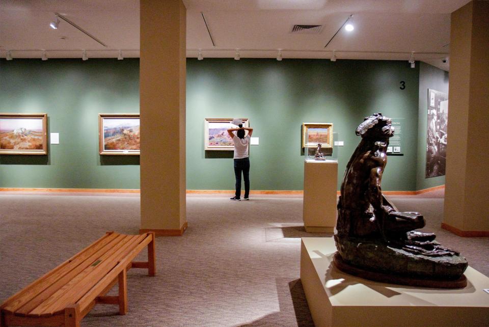 A visitor to the C.M. Russell Museum contemplates one of Russell's original paintings