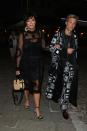 <p>Kris Jenner wears a sheer mesh midi dress layered over a black slip dress and a structured raffia handbag. </p>