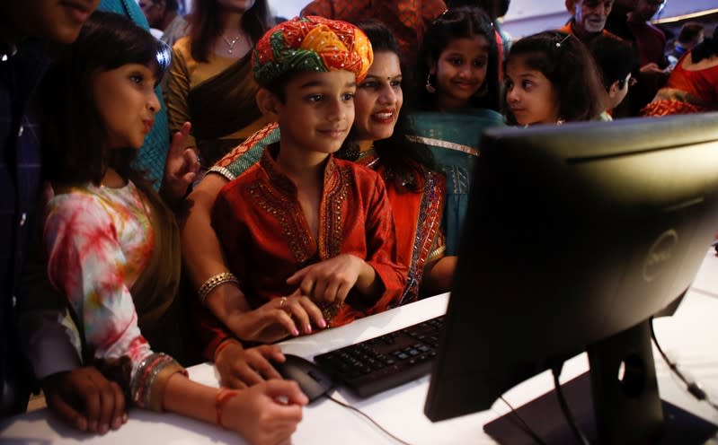 A stockbroker and her family watch a terminal during a special "muhurat" trading session for Diwali, the Hindu festival of lights, at the Bombay Stock Exchange (BSE) in Mumbai