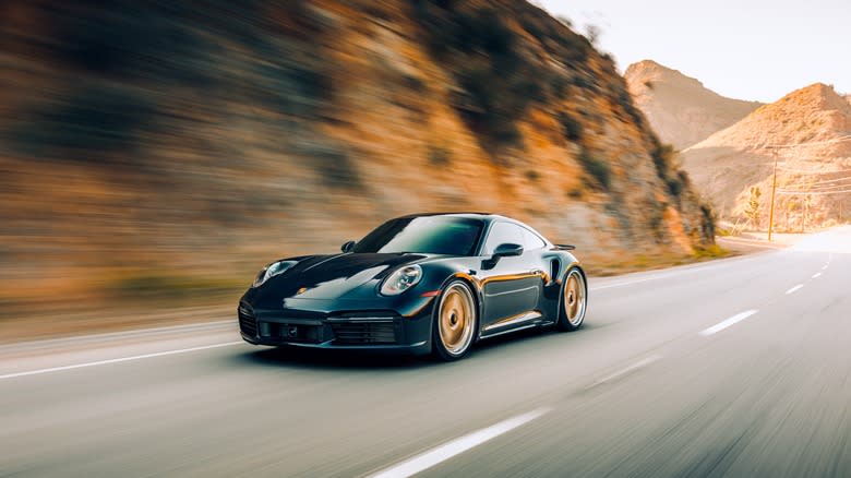 black porsche driving mountain road