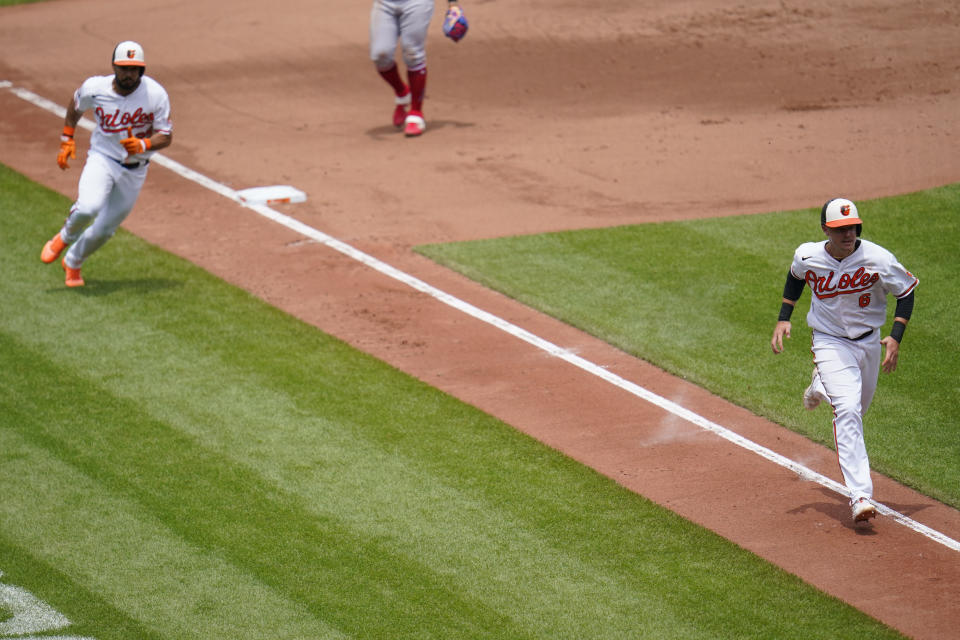 Baltimore Orioles' Ryan Mountcastle (6) runs home with teammate Anthony Santander (25) behind him as they both score on a single by Ramon Urias during the fourth inning of a baseball game against the Los Angeles Angels, Sunday, July 10, 2022, in Baltimore. (AP Photo/Julio Cortez)