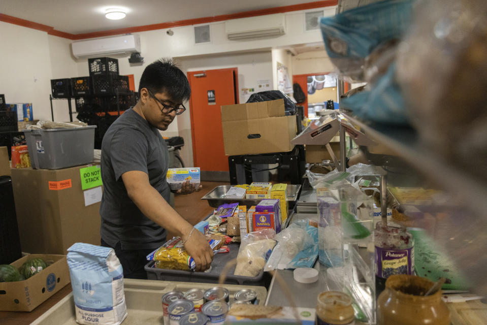 David Orellana organizes donations at Community Help in Park Slope, a soup kitchen and food pantry better known as CHiPS, on Friday, June 16, 2023 in New York. Charitable giving in the United States declined in 2022. The downturn in giving has led to issues at CHiPS, as it has in many charities across the country. (AP Photo/Jeenah Moon)