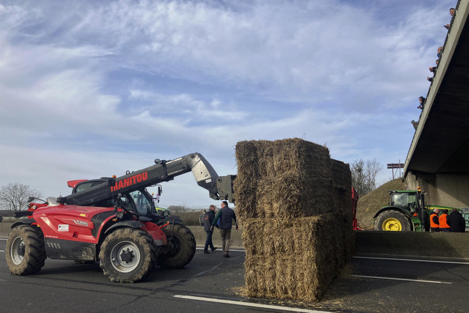 Farmers block a highway leading to Paris with hay bales, Monday, Jan. 29, 2024 near Jossigny, east of Paris. Protesting farmers sought to encircle Paris with tractor barricades and drive-slows on Monday, converging in their lumbering vehicles on France's capital to pressure the government over the future of their industry, which has been shaken by repercussions of the Ukraine war. (AP Photo/Sylvie Corbet)