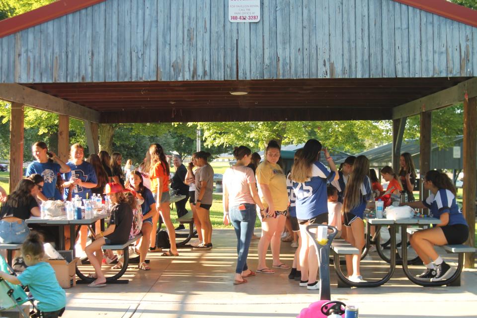 Game day rivalry is set aside as cheerleaders from Cambridge, Buckeye Trail and Meadowbrook high schools work together off the field to do face painting for youngsters during National Night Out.