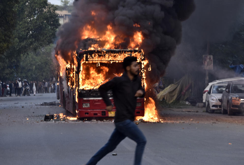A burning bus is seen after it was set on fire by demonstrators during a protest against the Citizenship amendment Act (CAA) at New Friends Colony in New Delhi, India on Dec. 15, 2019. | Sanjeev Verma—Hindustan Times via Getty Images