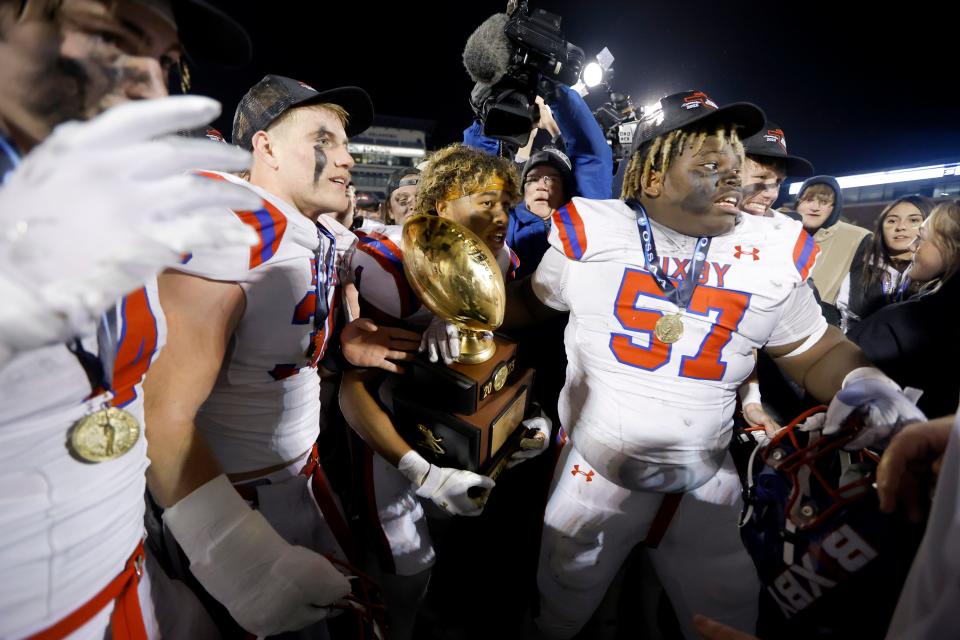 Bixby's Kordell Gouldsby carries the trophy as Bixby celebrates after winning the Class 6A-1 high school football championship game between Bixby and Jenks at Chad Richison Stadium in Edmond, Okla., Friday, Dec. 1, 2023. Bixby won 49-21.