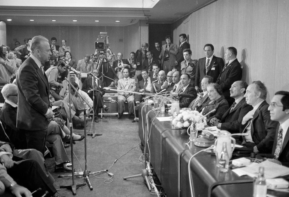 FILE - In this Nov. 21, 1977, file photo, Egyptian President Anwar Sadat is flanked by Israeli Labor Party leader Shimon Peres, right, and former Israeli Prime Minister Golda Meir, in the Israeli Parliament building, in Jerusalem, as they listen to former Israeli Prime Minister Yitzhak Rabin, left, at microphone. After decades of animosity and just four years after a bitter war, Sadat came with a historic offer of peace. Not all were enthralled with the visit. (AP Photo/File)