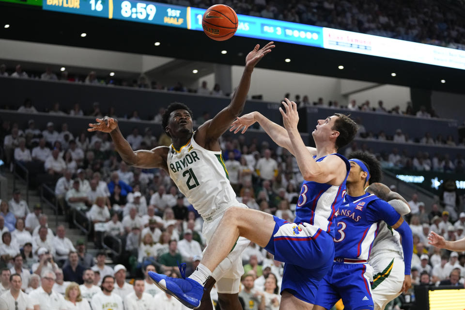 Baylor's Yves Missi (21) goes up for a shot against Kansas's Parker Braun, center, and Dajuan Harris Jr., right, during the first half of an NCAA college basketball game, Saturday, March 2, 2024, in Waco, Texas. (AP Photo/Julio Cortez)