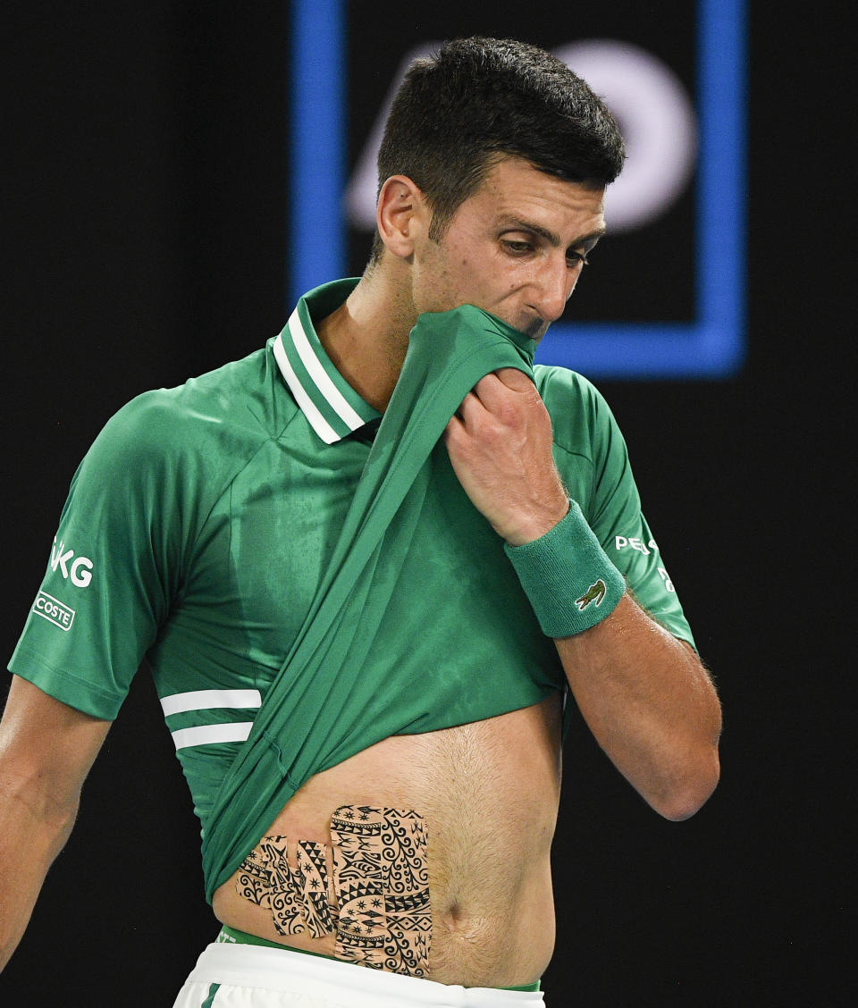 Serbia's Novak Djokovic wipes the sweat from his face during his quarterfinal match against Germany's Alexander Zverev at the Australian Open tennis championship in Melbourne, Australia, Tuesday, Feb. 16, 2021.(AP Photo/Andy Brownbill)