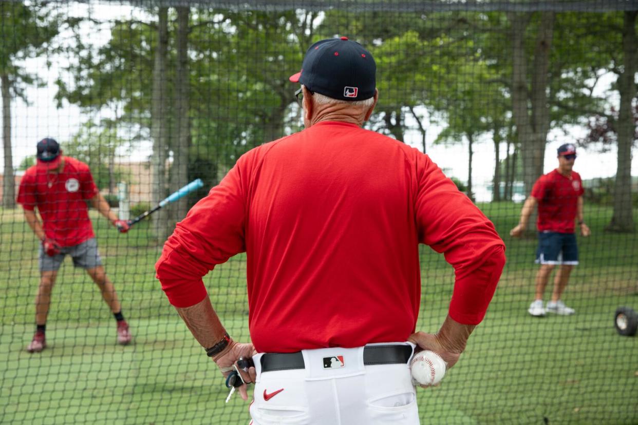 Coach Scott Pickler watches was players warm up in the batting cages.