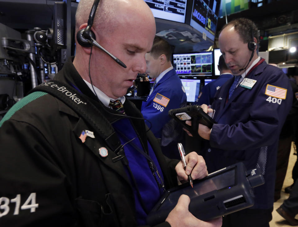 Traders Kevin Walsh, left, and Gordon Charlop work on the floor of the New York Stock Exchange Wednesday, April 30, 2014. The stock market is edging lower Wednesday after the U.S. economy slowed more drastically in the first quarter than economists had believed. (AP Photo)